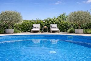 a swimming pool with two chairs and a table at Pula Paradise in Pula +9 photos