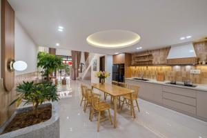 a kitchen with a wooden table and chairs at RubyHome in Thôn Nguyệt Biều