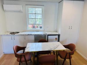 a kitchen with a table and chairs in a room at Venus Resort in The Entrance