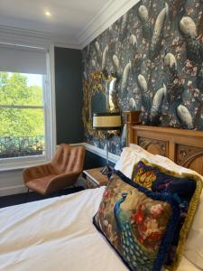 a bedroom with a bed and a wall covered in wallpaper at Kip 54 Monks Bar in Portsmouth