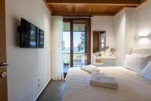 a bedroom with a bed with a television on the wall at Azure Residence Koumitsa in Nea Roda