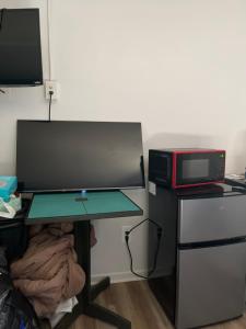 a desk with a computer monitor and a microwave at Zybnb in Livonia
