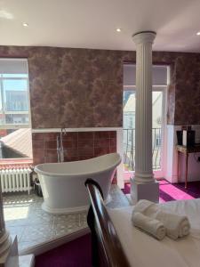 a bathroom with a tub and a large window at Kip 54 Monks Bar in Portsmouth