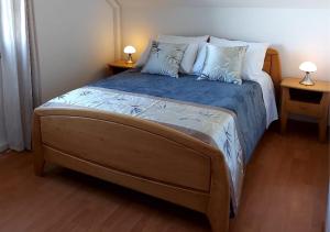 a bedroom with a large bed with blue sheets and pillows at Ilodays in La Plaine des Cafres