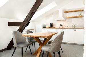 a kitchen and dining room with a wooden table and chairs at Aparthotel Pils 17 in Ventspils