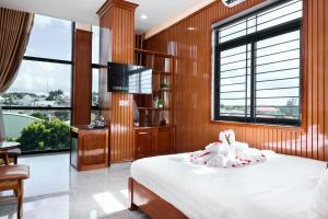 a bedroom with a bed and a flat screen tv at Phố Núi 2 Hotel in Pleiku