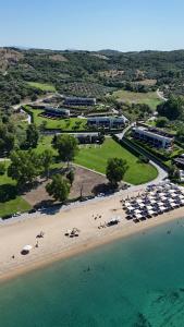 an aerial view of a beach with umbrellas and buildings at Azure Residence Koumitsa in Nea Roda