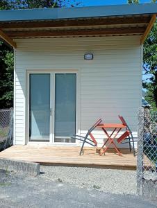 a picnic table on a wooden deck in front of a building at Studio chalet indépendant in Égletons