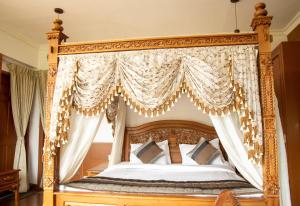 an ornate canopy bed in a bedroom at Western Valley Resorts Ooty in Ooty