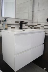 a white bathroom with a sink and a mirror at Il club degli scacchi in San Lorenzo del Vallo