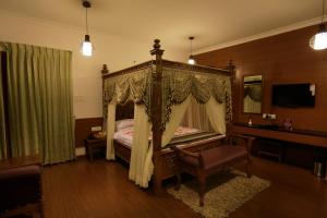 a bedroom with a canopy bed and a desk at Western Valley Resorts Ooty in Ooty