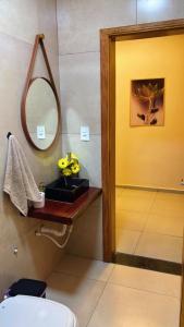 a bathroom with a sink and a mirror at Chácara pôr do sol in Araçoiaba da Serra +27 photos