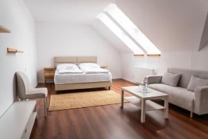 a bedroom with a bed and a couch and a table at Nidum - Šariš Park Hotel & Wellness in Prešov