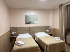 ein Zimmer mit zwei Betten und einem Gemälde an der Wand in der Unterkunft New Alexander Hotel in Genua + 42 Fotos
