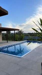 a swimming pool in the middle of a yard at Chácara pôr do sol in Araçoiaba da Serra
