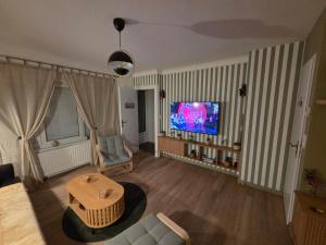 a living room with a couch and a tv at Ti a mor in Carnac
