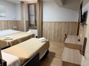 ein Hotelzimmer mit zwei Betten und einem Fernseher in der Unterkunft New Alexander Hotel in Genua