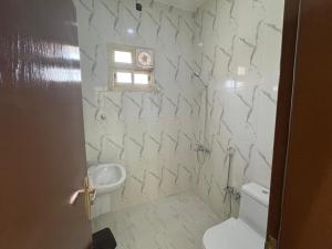 a bathroom with a toilet and a sink at Highland Residence Al namas in Lahbey