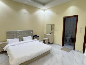a bedroom with a bed and a bathroom with a toilet at Highland Residence Al namas in Lahbey