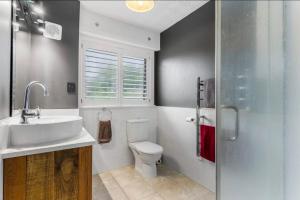 a bathroom with a sink and a toilet and a window at Amore Manor Auckland in Auckland +25 photos
