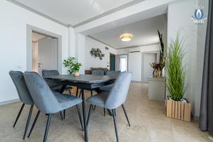a dining room with a black table and blue chairs at Daria Boutique Hotel in Eforie Sud
