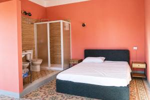 a bedroom with a bed and a bathroom with a toilet at Il club degli scacchi in San Lorenzo del Vallo