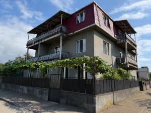 a tall building with a fence in front of it at Mziuri Cozy Guesthouse in Kobuleti