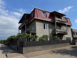 a building with a red roof on a street at Mziuri Cozy Guesthouse in Kobuleti