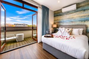 a bedroom with a large bed and a balcony at Villare Hotel Leicester City Centre in Leicester