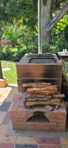 a brick grill with logs on top of it at Cabaña Las Lajas la pintada in La Pintada