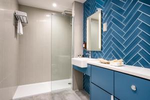 a bathroom with a sink and a shower at Villare Hotel Leicester City Centre in Leicester