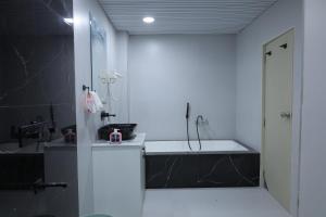 a bathroom with a sink and a bath tub at Hotel Ashok Vatika in Māharjhari +26 photos