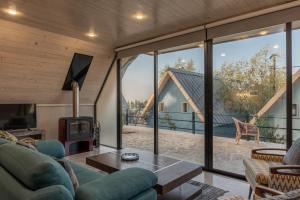 a living room with large glass windows and a fireplace at Maison Jwar - Luxury A-Shape Cabins - A Unique Summer Getaway in Ḩārat at Taḩtā