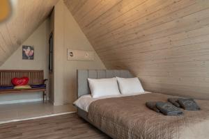 a bed in a room with a wooden ceiling at Maison Jwar - Luxury A-Shape Cabins - A Unique Summer Getaway in Ḩārat at Taḩtā +286 photos