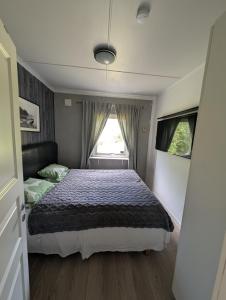 a small bedroom with a bed and a window at Hindås stuga in Hindås