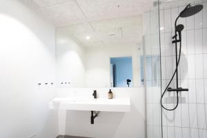 a white bathroom with a sink and a shower at Hotel Djurhuus in Tórshavn +69 photos