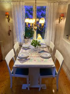 a dining room table with plates and a vase on it at Sjöberg's Cosy Cottage in Ljungby