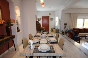 a living room with a wooden table and chairs at La maison de Catherine in Volos