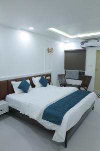 a bedroom with a large bed and two chairs at Hotel Ashok Vatika in Māharjhari
