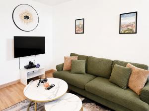 a living room with a green couch and a table at Maisonnette en duplex avec Jardin-Babyfoot et Billard in Outreau