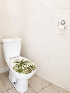 a bathroom with a white toilet with a plant seat at Maisonnette en duplex avec Jardin-Babyfoot et Billard in Outreau