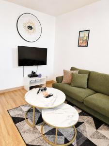 a living room with a couch and a table at Maisonnette en duplex avec Jardin-Babyfoot et Billard in Outreau +33 photos