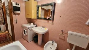 a pink bathroom with a sink and a toilet at Belvedere Pecol in Mareson +32 photos