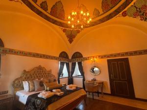 a bedroom with a bed and a chandelier at Kervansaray Antique Hotel in Çeşme