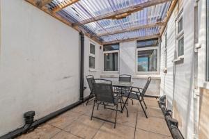 a patio with a table and chairs and a glass roof at Executive 4Bedroom Sleeps 9 City Centre Nearby in Parkside