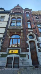 a tall brick building with a yellow sign on it at Hi bed & breakfast Liège in Liège