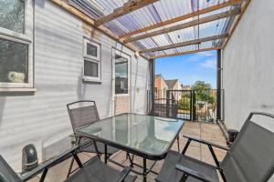 a glass table and chairs on a patio at Executive 4Bedroom Sleeps 9 City Centre Nearby in Parkside