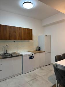 a kitchen with white cabinets and a refrigerator at Modi Living Apartment in Skopje