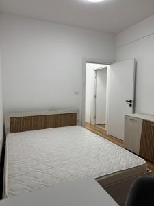 a white room with a bed and an open door at Modi Living Apartment in Skopje