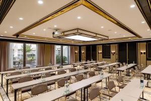 a large room with tables and chairs and windows at Steigenberger Hotel Bad Homburg in Bad Homburg vor der Höhe